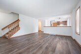 Located at 6801 Chester Dr in Madison, WI, this three-floor home offers a well-organized layout across its three levels. The main living area features rich hardwood-style flooring, warm wood-trimmed windows that invite natural light, and a central fireplace that serves as a focal point of the room. An open sightline connects the living room to the kitchen, which is equipped with dark wood cabinetry, stainless steel appliances including a refrigerator and electric range, and a light stone-finish countertop with a peninsula and built-in sink — ideal for both cooking and casual dining. Three bedrooms provide comfortable accommodations, with the primary bedroom offering a generous footprint, carpeted flooring, and its own closet. The additional bedrooms also feature carpet, wood-trimmed windows, and closet access. Two full bathrooms include tub-shower combinations with clean white surrounds and wood-toned vanities. The attached garage provides convenient interior access, while the unfinished basement presents a blank canvas with open framing overhead and a sump pump — offering significant potential for future use.