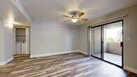 Located in Gilbert, AZ, this well-appointed one-bedroom, two-bathroom residence offers a thoughtfully designed single-floor layout with a variety of modern updates throughout. The open living room is finished with light wood-look flooring and features a ceiling fan with light fixture, a textured ceiling, and a sliding glass door that opens directly onto a private balcony, filling the space with natural light and providing seamless indoor-outdoor access. The kitchen is a functional highlight, showcasing a skylight, white upper cabinetry paired with gray lower cabinets, sleek white countertops, a peninsula with an undermount sink, and a full suite of stainless steel appliances including a range, over-the-range microwave, and refrigerator. The bedroom offers comfortable carpeting, a ceiling fan, and a window with natural light, complemented by a generously sized walk-in closet with built-in shelving and hanging rods for ample storage. Both bathrooms are clean and modern, featuring gray shaker-style vanities, white countertops, and light wood-look tile flooring. The overall aesthetic is neutral and contemporary, with soft gray tones, white trim, and consistent finishes throughout that create a cohesive and inviting atmosphere.