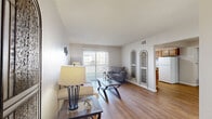 Located at 14881 E Fifth Cir in Aurora, CO, this one-bedroom, one-bathroom unit offers a well-organized, single-floor layout designed to maximize functionality. The living room features hardwood-style flooring, neutral walls, a textured ceiling, and a sliding glass door that opens to a private balcony, filling the space with natural light and outdoor views. Decorative wall accents add a touch of character to the room. Adjacent to the living room, a defined dining area provides an intimate setting highlighted by a pendant light overhead, while the connected galley-style kitchen is equipped with warm wood cabinetry, white appliances including a refrigerator, stove, and dishwasher, and a window that brings in additional natural light. The bedroom is a comfortable retreat with soft carpeting, a textured ceiling, and a bright window with blinds, complemented by two closets offering generous storage. The full bathroom features hardwood-style flooring, a wood-toned vanity with ample counter space, and a tub-shower combination enclosed by sliding glass doors. A hallway connects the rooms cohesively, completing this practical and comfortable floor plan.