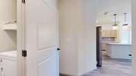 This single-floor space presents a clean, contemporary design highlighted by light wood-look luxury vinyl plank flooring that flows consistently throughout. The kitchen is a functional centerpiece, equipped with stainless steel appliances including a large side-by-side refrigerator, over-the-range microwave, and range. Light natural wood-toned cabinetry extends to the ceiling, providing generous storage, while the layout offers an open sightline into the adjoining living areas. Interior doors feature a classic two-panel design with matte black hardware, adding a modern contrast to the neutral cream-toned walls.

The bedrooms are well-proportioned, each benefiting from natural light through blinds-fitted windows. Closet options vary across rooms, with one bedroom featuring a sliding two-panel closet and another offering a dedicated walk-in closet equipped with built-in shelving and hanging rods — ideal for organized storage. A ceiling fan with pull-chain controls is installed in the primary bedroom area.

The bathroom is notably refined, showcasing a dual-sink vanity with light wood cabinetry, white countertops, and matte black faucets. The tub-shower surround is finished in large-format marble-look tile, creating an elevated, spa-like aesthetic. The overall ambiance of the space is bright, clean, and move-in ready.