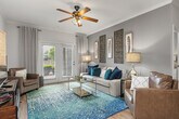 This thoughtfully designed 2-bedroom, 2-bathroom residence offers a seamless single-floor layout that balances comfort and functionality. Warm hardwood-style flooring flows throughout the main living areas, complementing the neutral tones and crown molding that lend a polished finish to the space.

The open-concept kitchen is a standout feature, showcasing gray cabinetry, granite countertops, stainless steel appliances, and a center island with bar seating — ideal for both everyday cooking and casual entertaining. The adjacent dining area provides a dedicated space for meals, while the living room impresses with its generous proportions, crown molding, and French doors that invite abundant natural light and outdoor views.

The primary bedroom offers a comfortable retreat, complete with a ceiling fan, hardwood-style floors, and direct access to an en-suite bathroom fitted with dark cabinetry. The second bedroom is well-sized with a bright window and ample room for furnishings. A dedicated walk-in closet with wire shelving provides practical storage. The second bathroom features tile flooring and a gray vanity, maintaining the cohesive design aesthetic found throughout the home. Together, the rooms create a balanced, inviting living environment with modern finishes and thoughtful details throughout.