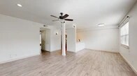 This thoughtfully laid-out 2-bedroom, 1-bathroom home offers a clean, modern aesthetic throughout its single floor. The open-concept living and kitchen area serves as the heart of the home, featuring light wood-look flooring, crisp white walls, and a decorative column that adds a subtle architectural touch. A ceiling fan anchors the living space, which flows seamlessly into the kitchen — separated by a half-wall pass-through that enhances connectivity while maintaining defined zones. The kitchen is equipped with stainless steel appliances, including a refrigerator and dishwasher, with recessed lighting above.

Both bedrooms continue the light flooring and neutral color palette, each fitted with ceiling fans and windows dressed with horizontal blinds that allow natural light to filter in while maintaining privacy. The primary bedroom offers a comfortable footprint, ideal for a full furniture arrangement. A hallway connects the bedrooms to the shared bathroom, which stands out with its herringbone-patterned tile walls in the walk-in shower, wood-look tile flooring, and matte black fixtures — a stylish, contemporary finish. Two closets provide ample storage throughout the unit, completing this clean and functional home.