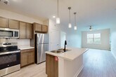 Located at 964 Constitution Blvd in Rock Hill, SC, this well-appointed 2-bedroom, 2-bathroom single-story residence offers a thoughtfully designed open-concept layout. The kitchen serves as the heart of the home, featuring rich wood cabinetry, stainless steel appliances including a refrigerator, microwave, and range, and a central island with a built-in sink and light countertops. Elegant pendant lighting hangs above the island, adding a stylish focal point. The kitchen flows seamlessly into the living area, which is finished with light wood-style flooring and a ceiling fan, creating a bright, airy atmosphere. Both bedrooms are carpeted for comfort and include ceiling fans and windows that invite natural light. The spacious primary bedroom offers generous proportions with an outdoor view. The two bathrooms are consistently finished with wood-toned vanities, light countertops, and wood-style tile flooring. One bathroom features a tub-shower combination, while the other includes grab bars and a more accessible layout. Two closets provide ample storage throughout the home. The neutral color palette and clean finishes give the space a move-in-ready appeal.