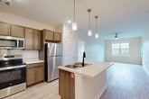 Located at 964 Constitution Blvd in Rock Hill, SC, this well-appointed 2-bedroom, 2-bathroom single-story residence offers a thoughtfully designed open-concept layout. The kitchen serves as the heart of the home, featuring rich wood cabinetry, stainless steel appliances including a refrigerator, microwave, and range, and a central island with a built-in sink and light countertops. Elegant pendant lighting hangs above the island, adding a stylish focal point. The kitchen flows seamlessly into the living area, which is finished with light wood-style flooring and a ceiling fan, creating a bright, airy atmosphere. Both bedrooms are carpeted for comfort and include ceiling fans and windows that invite natural light. The spacious primary bedroom offers generous proportions with an outdoor view. The two bathrooms are consistently finished with wood-toned vanities, light countertops, and wood-style tile flooring. One bathroom features a tub-shower combination, while the other includes grab bars and a more accessible layout. Two closets provide ample storage throughout the home. The neutral color palette and clean finishes give the space a move-in-ready appeal.