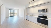 This contemporary apartment in Boca Raton, FL offers 1010 square feet of thoughtfully designed living space. The open-concept floor plan maximizes the sense of spaciousness, with light wood flooring throughout creating a cohesive look. The kitchen is a highlight, featuring sleek white cabinetry, stainless steel appliances, and track lighting, opening seamlessly to the living area.

Both bedrooms are generously sized, with the primary bedroom measuring 180 square feet. Large windows in the bedrooms and living areas flood the space with natural light and offer city views, while providing privacy with horizontal blinds. The bathrooms are modern and stylish, with one featuring a glass-enclosed shower and another a shower/tub combination, both finished with elegant tile work.

Storage is ample, with built-in closets in the bedrooms and a separate closet area with wire shelving. The apartment's clean lines, neutral color palette, and minimalist design create a contemporary aesthetic that's both functional and visually appealing. Located in the desirable 33432 zip code of Boca Raton, this apartment combines urban convenience with modern comfort.
