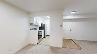 Located at 3048 Woodbridge Dr SE in Kentwood, Michigan, this single-floor unit offers a clean, functional layout designed for comfortable everyday living. The open-concept design connects the living area to the kitchen through a well-defined archway, creating a seamless flow between spaces. The kitchen is efficiently arranged with white shaker-style cabinetry, light quartz countertops, light wood-look vinyl plank flooring, a stainless steel range with overhead ventilation hood, and a refrigerator — providing all the essentials in a tidy, modern package. The living area is carpeted and features a sliding glass door fitted with vertical blinds that opens to a balcony, allowing natural light and outdoor views to enhance the space. The bedrooms are carpeted and well-proportioned, each featuring windows with blinds that bring in natural light. Interior doors with matte black hardware add a contemporary touch throughout. The bathroom is thoughtfully updated with a white vanity, stone-look countertop, a framed mirror with dark trim, matte black fixtures, and wood-look flooring, complemented by a shower with a curtain rod. The unit's neutral white walls and consistent finishes throughout create a bright, cohesive atmosphere well suited for a variety of living arrangements.