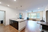 Located at 111 Edgeway Dr in Winston-Salem, NC, this single-floor residence offers a thoughtfully designed open-concept layout with 2 bedrooms, 3 bathrooms, and a dedicated laundry room. The kitchen is a standout feature, showcasing dark cabinetry, granite-look countertops, black appliances including a full-size refrigerator and range, and a large peninsula island with seating for two — illuminated by stylish pendant lighting. The kitchen flows seamlessly into the living area, which is anchored by large windows that invite generous natural light and offer pleasant wooded views. Hardwood-style flooring runs throughout the main living areas, adding warmth and continuity. The spacious primary bedroom features plush carpeting, a ceiling fan, and a large window overlooking greenery, providing a comfortable retreat. The second bedroom, also carpeted, offers versatile space suitable for a guest room or home office. The three bathrooms are finished with wood-style flooring, granite-topped vanities with dark cabinetry, and tub-shower combinations. A dedicated laundry room houses a full-size washer and dryer with overhead shelving for added storage. Two closets provide additional organization throughout the home. The clean, neutral color palette and modern finishes create a bright, contemporary ambiance throughout.