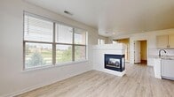 This contemporary apartment at 9850 Zenith Meridian Dr in Englewood, CO, offers a spacious and well-designed living space across two floors. The interior is characterized by an open concept layout, promoting a sense of flow and connectivity between rooms. Light wood-look flooring runs throughout, complementing the crisp white walls and creating a bright, airy atmosphere.

The kitchen is a standout feature, boasting white cabinetry, stainless steel appliances, and elegant granite countertops. A central island provides additional workspace and casual dining options. Large windows in the living areas and bedrooms allow for abundant natural light and offer picturesque views of the surrounding landscape.

The bathrooms are modern and functional, featuring clean lines and glass shower enclosures. The master bedroom includes a walk-in closet with ample shelving for organization. Ceiling fans in the bedrooms provide comfort and air circulation.

The apartment's design emphasizes storage solutions, with built-in closets and shelving units in various rooms. The overall aesthetic is minimalist and contemporary, creating a blank canvas for personalization while maintaining a sense of sophistication. With its thoughtful layout and high-quality finishes, this apartment offers a comfortable and stylish living environment in a desirable Colorado location.
