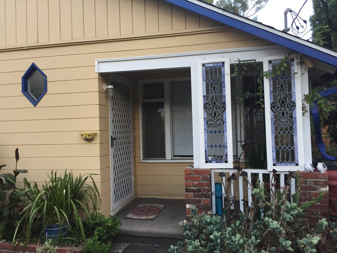 Front door porch with stained glass, yard has a hedge for privacy - 1372 Neola St