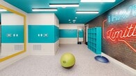 Located at 120 Piedmont Ave NE in Atlanta, GA, this fitness center offers a comprehensive workout facility spread across a single floor. The space is divided into two distinct gym areas, each thoughtfully designed to support a range of fitness activities.

The main gym area is bathed in abundant natural light, courtesy of floor-to-ceiling glass curtain walls that offer views of the surrounding urban landscape. Soaring ceilings, ceiling fans, and neutral-toned geometric-patterned carpeting create a bright and airy environment. This space is well-appointed with a full array of cardio equipment—including treadmills, ellipticals, and a stair climber—as well as a dedicated strength training zone featuring cable machines, a power rack with free weights, a dumbbell rack, and adjustable benches. Large wall mirrors further enhance the sense of openness.

The second gym area presents a striking contrast in design, with bold teal and white walls, a vibrant teal ceiling, and polished terrazzo flooring. A neon-lit motivational mural on an exposed brick wall energizes the space. This versatile studio accommodates functional and group fitness training, equipped with spinning bikes, plyo boxes, balance tools, and stability balls. Built-in teal shelving provides convenient storage. A dedicated yoga studio room is also accessible from this area, making the space adaptable for a wide variety of fitness disciplines.