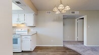 Located at 5350 E Taylor St in Phoenix, AZ, this single-floor, three-bedroom, two-bathroom home offers a practical and comfortable layout. The kitchen features white cabinetry, white appliances including a refrigerator, range, and dishwasher, light countertops, and wood-look flooring. A window above the sink brings in natural light, and the kitchen opens into a dining area illuminated by a multi-light chandelier. The living room is carpeted and features a sliding glass door that opens to a private outdoor patio, filling the space with natural light and providing easy outdoor access. Three bedrooms offer plush carpeting, neutral-toned walls, and windows with vertical blinds. The spacious primary bedroom provides a comfortable retreat. Two bathrooms include clean white fixtures and wood-look flooring; one features a single vanity with a medicine cabinet mirror, while the other includes a full bathtub and shower combo with a white vanity. Textured ceilings are consistent throughout, contributing to the home's cohesive, understated aesthetic. A hallway connects the bedrooms and bathrooms, and a closet provides additional storage. The warm, neutral palette throughout creates a bright and welcoming atmosphere.