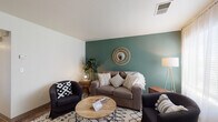 Located at 1959 Lake Blvd in Davis, CA, this single-floor unit offers a thoughtfully designed layout with a warm, bohemian aesthetic throughout. The living room serves as the heart of the space, anchored by a bold teal accent wall, a circular rattan mirror, and natural light streaming through sheer curtain-draped windows — creating an inviting and stylish atmosphere for relaxing or entertaining.

The kitchen is well-appointed with oak cabinetry, black appliances including a refrigerator, range, and microwave, and an L-shaped peninsula with a teal base topped with a light countertop. Bar-style seating adds a casual dining element ideal for everyday use.

The bedrooms are bright and comfortable, each featuring carpet flooring, large windows with blinds and sheer curtains that bring in ample natural light, and dedicated study areas with desks. One bedroom includes a spacious walk-in closet with double hanging rods, offering generous storage capacity.

A bonus room with tile flooring, a ceiling fan, and a window overlooking greenery provides flexible space suitable as a dining area, office, or creative studio. The bathroom features a wood-toned vanity with a single sink, a mirror, and a combined tub-shower. The overall design blends functionality with a cohesive, earthy bohemian style throughout.