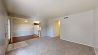 Located at 9310 Starcrest Drive in San Antonio, Texas, this single-story 2-bedroom, 1-bathroom home offers a practical and comfortable layout. The living and dining areas flow openly together, featuring neutral carpet throughout and light-toned walls that create a bright, airy feel. The kitchen is positioned adjacent to the dining area and is equipped with warm wood-toned cabinetry, light speckled countertops, a double-basin sink, a white electric range, and light tile flooring — offering ample storage and counter workspace. A hallway connects the main living areas to the private quarters of the home. The spacious primary bedroom is generously sized, featuring plush carpet, a ceiling fan with light fixture, and a closet. The second bedroom is similarly appointed with carpet, a ceiling fan, a closet with bi-fold doors, and a large window that fills the room with natural light. Three closets throughout the home provide excellent storage options, complemented by a dedicated utility room. The full bathroom features tile flooring, a vanity with a marble-style countertop, a framed mirror, and a combined tub/shower. Clean, neutral finishes throughout give the home a move-in ready character.
