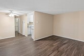Located at 825 Tamarack Ave in Brea, California, this single-floor residence offers a straightforward and functional layout designed for comfortable everyday living. The main living area is open and well-proportioned, featuring dark hardwood-style flooring that extends throughout the unit, warm neutral wall tones, and a textured ceiling that adds subtle visual character. A ceiling fan with a light fixture provides both airflow and ambient lighting to the living space.

The galley-style kitchen is efficiently organized, with white cabinetry lining both sides, granite-look countertops, a white gas range, and a stainless steel sink. A paneled ceiling with recessed lighting illuminates the workspace, while the continuous hardwood-style flooring ties the kitchen seamlessly into the rest of the unit. A full-size refrigerator is integrated into the kitchen layout.

A dedicated hallway connects the living areas to the bedroom and bathroom. The bedroom is a generously sized, quiet room with the same consistent flooring and neutral wall finish, offering a versatile and move-in ready space. The bathroom features a clean, all-white tub and shower combination with chrome fixtures, complemented by warm beige walls for a simple, tidy aesthetic. The overall design of the space prioritizes practicality and ease of use throughout.