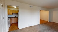 Located at 13050 W Cedar Dr in Lakewood, Colorado, this single-floor unit offers a practical and functional layout throughout. The spacious living room is a standout feature, centered around a classic white-painted fireplace and finished with wall-to-wall carpet that extends into the adjoining areas. A sliding glass door fills the room with natural light and opens directly onto a private balcony, providing outdoor access and views of the surrounding neighborhood.

The kitchen is efficiently designed with white cabinetry, ample counter space, a built-in sink, and white appliances including a range and refrigerator. Wood-look flooring in the kitchen and entryway areas provides a durable contrast to the carpeted living spaces. A dedicated utility or workspace area features a built-in counter with a sink and cabinet storage beneath, adding versatile functionality to the unit.

The bedroom offers a quiet, carpeted retreat with easy access to adjacent rooms. The full bathroom is clean and straightforward, featuring a tub-shower combination, a vanity with storage, and wood-look tile flooring. Textured ceilings are consistent throughout the unit, and central HVAC vents are present in multiple rooms. The overall layout is well-connected and easy to navigate, offering comfortable single-floor living in a convenient Lakewood location.