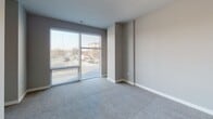 Located at 20 W Northwest Highway in Mount Prospect, Illinois, this single-floor unit offers a thoughtfully designed layout with modern finishes throughout. The kitchen is a standout feature, showcasing bold dark shaker-style cabinetry that extends to the ceiling, crisp white quartz countertops, a classic subway tile backsplash, and a full suite of stainless steel appliances including a refrigerator, electric range, built-in microwave, and dishwasher. Light wood-look flooring runs through the kitchen and connecting areas, adding warmth and continuity. The living area is carpeted and bathed in natural light through a large sliding glass door that frames views of the surrounding neighborhood, creating an open and airy atmosphere. The bedroom is generously proportioned with soft carpeting, neutral walls, and includes a closet alongside an open doorway to the adjacent hallway. The bathroom is cleanly finished with large-format tile surrounding a full soaking tub and shower combination, complemented by light wood-look flooring, neutral gray walls, and standard fixtures. Throughout the unit, a consistent neutral color palette and contemporary design choices contribute to a clean, modern ambiance well-suited for comfortable everyday living.