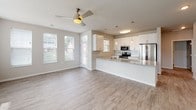 Located at 6616 Century Ave in Middleton, Wisconsin, this single-floor unit offers a clean, modern design with a neutral color palette and contemporary finishes. The open-concept living and kitchen area forms the heart of the space, where light wood-look vinyl plank flooring extends throughout and ceiling fans provide both function and style. Multiple windows fitted with blinds allow natural light to flow freely, creating a bright and welcoming atmosphere.

The kitchen is well-appointed with white shaker-style cabinetry, a subway tile backsplash, and granite countertops that extend across a peninsula island with built-in sink — ideal for both meal preparation and casual dining. Stainless steel appliances, including a refrigerator, range, and microwave, complement the sleek design. Pendant lighting above the island adds a refined touch.

The bedrooms feature plush carpeting, ceiling fans, and windows with outdoor views. One bedroom includes a walk-in closet with built-in shelving, providing ample storage. The bathrooms are finished with granite-topped white vanities, large framed mirrors, and wood-look tile flooring, maintaining the cohesive modern aesthetic found throughout the unit. Overall, the space presents a well-designed, move-in-ready environment with consistent, quality finishes from room to room.