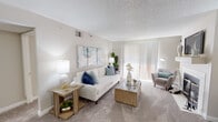 This single-floor residence offers a thoughtfully designed layout that balances comfort and functionality throughout. The living room serves as the heart of the home, featuring plush carpeting, a textured ceiling, and a large sliding glass door framed by vertical blinds that flood the space with natural light. Built-in shelving flanks a fireplace, adding both storage and character to the room's bright, neutral palette.

The galley-style kitchen is efficiently arranged with white cabinetry lining both sides, granite-look countertops, wood-look flooring, and stainless steel appliances including a dishwasher, microwave, and electric range — providing ample workspace for cooking and meal prep.

Two well-proportioned bedrooms each feature soft carpeting, textured ceilings, and windows dressed with blinds and sheer curtains that invite natural light while maintaining privacy. The rooms offer a calm, restful ambiance with neutral wall tones throughout.

Two full bathrooms serve the residence, each outfitted with a tub-shower combination, white tile surrounds, wood-look flooring, and granite-look vanity countertops, reflecting a clean and consistent design language.

A dedicated in-unit laundry room houses a full-size front-loading washer and dryer set, accompanied by shelving for storage — a practical and convenient feature rounding out this well-equipped home.