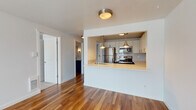 Located at 602 Galer Street in Seattle's desirable Queen Anne neighborhood, Unit 408 is a well-appointed single-floor residence that blends classic design with modern updates. Rich hardwood flooring flows throughout the main living areas, anchored by a clean, white-surround fireplace that serves as a focal point in the spacious living room. Natural light filters in through blinds-fitted windows, lending a bright and airy atmosphere throughout.

The kitchen is a standout feature, designed with a pass-through peninsula that opens to the living and dining area. It is outfitted with stainless steel appliances — including a range, microwave, and refrigerator — complemented by crisp white upper cabinetry, bold navy lower cabinetry, light quartz countertops, and a classic subway tile backsplash. Pendant lighting adds a warm, polished touch overhead.

The bedrooms are carpeted for comfort and each include windows with natural views and baseboard heating. The bathroom is thoughtfully finished with a bold navy vanity, white quartz countertop, modern brushed nickel fixtures, and a tub-shower combination. A dedicated laundry area with in-unit washer and dryer adds everyday convenience, alongside ample closet storage with built-in shelving.