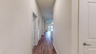 Located at 1235 NASA Pkwy in Houston, TX, this thoughtfully designed 2-bedroom, 2-bathroom residence offers a comfortable and modern living experience across a single floor. The open-concept living and kitchen area is anchored by warm hardwood-style flooring, recessed lighting, and a ceiling fan, creating a bright and inviting atmosphere. The kitchen is a standout feature, boasting rich dark wood cabinetry, granite countertops, a subway tile backsplash with under-cabinet lighting, stainless steel appliances including a gas range, microwave, refrigerator, and dishwasher, plus a central island for additional prep space. Both bedrooms are carpeted and equipped with ceiling fans; the primary bedroom opens to a private balcony with decorative ironwork railing. The primary bathroom impresses with large-format marble-look tile flooring, a dual-sink granite vanity, and a glass-enclosed walk-in shower. The secondary bathroom mirrors the same refined tile work and granite countertop details. A spacious walk-in closet with wire shelving provides ample storage. Clean white walls and neutral tones throughout lend the space a polished, move-in-ready feel.