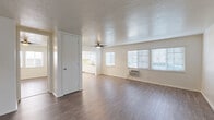 Located at 4950 Hayter Ave in Lakewood, California, this single-story, 3-bedroom, 1-bathroom home offers a practical and comfortable layout. The open living area features durable wood-style flooring, a textured ceiling, and a ceiling fan, creating a bright and airy atmosphere. Large windows fitted with blinds allow natural light to fill the space throughout the day. A wall-mounted heater and a window AC unit provide year-round climate control.

The kitchen is outfitted with ample white cabinetry, generous counter space, and white appliances including a gas range and over-the-range microwave, offering a clean and functional cooking environment. The layout flows seamlessly from the kitchen into the living area, making the space feel open and connected.

The three bedrooms are well-proportioned, with the primary bedroom offering a comfortable footprint. Each bedroom includes wood-style flooring, windows with natural light, and ceiling fans where noted. A hallway connects the bedrooms to the shared full bathroom, which features a tub/shower combination, a vanity sink, and a window for ventilation. The overall design is clean, neutral, and move-in ready, suited for a variety of living arrangements.