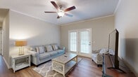 This well-appointed two-bedroom, two-bathroom home in Florence, South Carolina, offers a comfortable and functional single-floor layout. Throughout the home, warm wood-style flooring and neutral tones create a cohesive, inviting atmosphere, complemented by crown molding and textured ceilings.

The living room serves as the heart of the home, featuring a ceiling fan with light fixture and French doors that open to the outdoors, filling the space with natural light. Adjacent to the living area, a dedicated dining space is highlighted by an elegant pendant chandelier. The kitchen features a peninsula with granite-style countertops, warm wood cabinetry, black appliances, and pendant lighting — all open to the dining area for easy everyday living.

A hallway leads to both bedrooms, each equipped with ceiling fans and ample natural light from windows. The spacious primary bedroom includes its own closet, while both bedrooms are well-served by two full bathrooms, each featuring a single vanity with rich wood cabinetry and a shower-tub combination.

A dedicated laundry room houses a full-size washer and dryer with overhead cabinetry for additional storage. Two closets throughout the home provide practical organization. This residence offers a complete, move-in-ready living experience in a clean, well-maintained setting.