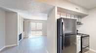 Located at 1500 Magruder St in El Paso, Texas, this 2-bedroom, 2-bathroom single-floor home offers a well-organized layout with a comfortable, functional design throughout. Light wood-style flooring flows consistently across the main living areas, lending a clean and cohesive aesthetic.

The combined kitchen and living room area serves as the heart of the home. The living room features a brick fireplace flanked by built-in shelving, a textured ceiling, and a sliding glass door that opens to a private balcony with outdoor views. The kitchen is outfitted with gray cabinetry, white quartz-style countertops, a subway tile backsplash, a double stainless steel sink, and a black dishwasher, with a stainless steel refrigerator completing the appliance package.

Both bedrooms are generously proportioned, each equipped with a ceiling fan with light fixture and a window that allows natural light to fill the space. The primary bedroom includes access to a dedicated closet with built-in shelving rods for organized storage. A second closet provides additional storage space.

The bathrooms are finished in a clean, neutral style, with one featuring a shower-tub combination and brushed nickel hardware. The textured walls and consistent light tones throughout contribute to a bright, airy ambiance across the entire home.
