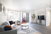 This thoughtfully designed 2-bedroom, 1-bathroom residence offers a functional and stylish single-floor layout. The open-concept living, dining, and kitchen area forms the heart of the home, filled with natural light streaming through large windows and a sliding glass door that leads to a private balcony. The living room features light hardwood-style flooring, a textured ceiling, and a clean, neutral color palette that creates a bright and welcoming atmosphere.

The kitchen is outfitted with white shaker-style cabinetry, quartz countertops, a peninsula with an undermount sink, and a full suite of stainless steel appliances including a refrigerator, range, microwave, and dishwasher. A dedicated dining area sits adjacent to the kitchen, offering a defined space for meals. A hallway connects the main living area to the private quarters.

The primary bedroom is a comfortable retreat with a window offering outdoor views, light flooring, and generous wall space. The second bedroom mirrors the same clean aesthetic. The shared full bathroom features a long vanity with quartz countertops, white cabinetry with matte black hardware, light wood-style flooring, and a shower-tub combination. Throughout the residence, consistent finishes and a neutral tone create a cohesive and modern living environment.