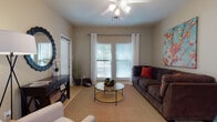 Located at 830 Fasken Blvd in Laredo, Texas, this single-floor residence offers a thoughtfully designed layout that balances comfort and functionality. The living area serves as the heart of the home, featuring light wood-style flooring, a ceiling fan with integrated lighting, and large windows dressed with blinds and curtains that invite an abundance of natural light. A decorative console table and round mirror accent one wall, while a welcoming seating arrangement anchors the space around a circular glass coffee table. The kitchen is laid out in a galley style, equipped with dark wood cabinetry, ample counter space, a double basin sink, and white appliances including a range and built-in microwave. Light tile flooring and an open passageway keep the kitchen feeling connected and accessible. The bedroom is a serene retreat finished with plush carpet, a ceiling fan, and a large window that allows natural light to filter in. Warm-toned walls and thoughtful lighting create a relaxing ambiance. The bathroom features clean tile flooring, a tub-shower combination, and bright, neutral finishes throughout. Overall, the residence presents a cohesive, neutral color palette with warm accents, offering a comfortable and inviting living environment.