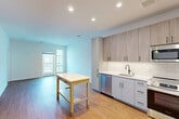 Located at 6402 America Blvd in Hyattsville, MD, this well-designed one-bedroom, one-bathroom residence offers a thoughtful layout across a single floor. The open-concept kitchen and living area serves as the heart of the unit, featuring warm hardwood-style flooring that flows throughout. The kitchen is outfitted with modern two-tone cabinetry — combining light wood uppers with soft grey lowers — complemented by a white subway tile backsplash, white quartz countertops, and a full suite of stainless steel appliances including a refrigerator, range, microwave, and dishwasher. Recessed lighting illuminates the space efficiently. The living area benefits from natural light and direct access to a private balcony with exterior views. The bedroom is a comfortable, bright room with a dedicated walk-in closet featuring built-in shelving and hanging rods, plus an additional window overlooking the surrounding neighborhood. The bathroom is finished with elegant marble-style tile flooring, a white subway-tiled tub-shower combination, a clean white vanity with a quartz countertop, and polished chrome fixtures. Three closets throughout the unit provide generous storage for everyday living.