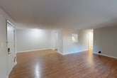 This 2-bedroom, 1-bathroom residence offers a practical and comfortable single-floor layout with warm hardwood flooring extending throughout every room. The open combined living and dining area is generously proportioned, featuring a textured ceiling, neutral walls, and a pass-through window connecting to the kitchen, making the space feel cohesive and bright. A front entry with dual doors leads directly into this expansive common area.

The kitchen is efficiently designed in a U-shaped configuration, equipped with stainless steel appliances — including a refrigerator, range, and dishwasher — complemented by gray cabinetry, light countertops, and a pantry for additional storage.

The spacious primary bedroom includes a large sliding closet and baseboard heating, while the second bedroom features a window with outdoor green views and its own baseboard heating. Both rooms offer clean, neutral tones and hardwood floors. A total of four closets throughout the unit provides ample storage.

The bathroom is equipped with a full tub-shower combination, a wide vanity with white cabinetry, a large mirror with overhead lighting, and tile surround. The layout is completed by a dedicated hallway connecting all rooms efficiently, ensuring a smooth flow throughout the home.