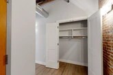 Located at 119 Hotel St in Utica, NY, this thoughtfully designed unit blends industrial character with modern finishes across a well-proportioned single-floor layout. Soaring ceilings with exposed wooden beams and visible ductwork lend an authentic loft aesthetic throughout, while light hardwood flooring ties the living spaces together seamlessly.

The open-concept kitchen is a standout, featuring two-tone gray cabinetry, quartz countertops, a subway tile backsplash, stainless steel appliances, and a peninsula with pendant lighting overhead. Original brick columns and wood beam details add warmth and texture to the space.

Two living areas offer flexibility for living and dining arrangements, each showcasing dramatic exposed brick walls and large black-framed windows that invite natural light and urban views of the surrounding Utica streetscape.

The unit includes two bathrooms finished to a high standard. The primary bathroom features a double navy vanity with quartz countertops, a large backlit mirror, hexagonal tile flooring, and exposed brick accents. The second bathroom mirrors the design language with a single navy vanity, backlit mirror, and a tub-shower combination.

Three closets, including one with built-in shelving and hanging rods, provide generous storage. A hallway and entrance area complete the functional layout of this distinctive, character-rich urban residence.