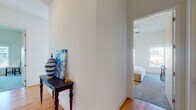 This thoughtfully designed two-bedroom, two-bathroom residence spans a single floor and delivers a contemporary urban living experience. The open-concept living area is anchored by expansive floor-to-ceiling windows and sliding glass doors that lead to a private balcony, flooding the space with natural light and framing impressive city skyline views. Light hardwood flooring runs throughout the main living areas, complementing the bright, neutral palette of the interior.

The kitchen is outfitted with dark wood cabinetry, granite countertops, a classic white subway tile backsplash, and a full suite of stainless steel appliances, including a refrigerator, range, microwave, and dishwasher. A large window above the sink provides additional natural light and urban views, making the kitchen as functional as it is visually appealing.

Both bedrooms are comfortably proportioned, with soft carpeting and ample natural light. One bedroom features a walk-in closet with built-in shelving and drawer storage. The two bathrooms mirror each other in design, each featuring a tiled walk-in shower with subway tile surround, granite-topped dark wood vanity, and large-format tile flooring. A welcoming hallway with warm wood flooring and decorative accents connects the living spaces to the private quarters, completing this well-balanced urban residence.