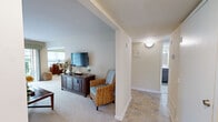 Located at 108 Lords Ct in Virginia Beach, Virginia, this single-floor, one-bedroom, one-bathroom residence offers a thoughtfully arranged layout across a comfortable footprint. The living room is a standout feature, bathed in natural light through large sliding glass doors that open to a view of lush greenery outside. Soft carpet flooring, neutral walls, and an open feel make this space both inviting and functional.

Adjacent to the living room, the dining area accommodates a round dining table beneath a modern overhead light fixture, with a window dressed in decorative valances that brings in additional natural light. The kitchen is well-appointed with warm oak cabinetry, granite-style countertops, a tile backsplash, recessed lighting, and black Whirlpool appliances including a gas range, refrigerator, and dishwasher.

The spacious primary bedroom features plush carpeting, neutral tones, and ample room for a full bedroom suite. The bathroom is clean and functional, featuring tile flooring, a dark-cabinet vanity with a white countertop, and a well-lit mirror. Additional highlights include two closets, a dedicated laundry area, a utility room, and a hallway connecting all areas seamlessly for practical, comfortable everyday living.