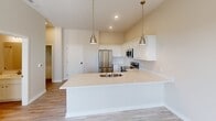 Located at 900 3rd St SE in Cedar Rapids, Iowa, this one-bedroom, one-bathroom residence offers a thoughtfully designed layout with modern finishes throughout. The open-concept kitchen is a standout feature, showcasing crisp white shaker cabinetry, light quartz countertops, a large peninsula with an undermount sink, stainless steel appliances including a refrigerator, range, built-in microwave, and dishwasher, and stylish brushed gold pendant lighting overhead. Light wood-tone flooring runs through the kitchen and main living areas, creating a warm and cohesive aesthetic. The living room benefits from large windows that invite abundant natural light and offer views of the surrounding Cedar Rapids cityscape, complemented by a ceiling fan for added comfort. The bedroom features plush carpeting, elevated ceilings with a visible HVAC vent, and a spacious closet with built-in shelving, along with access to an additional nook area ideal for a desk or workspace. The bathroom is finished with wood-look flooring, a full soaking tub and shower combo with brushed nickel fixtures, and a clean white vanity. A stacked in-unit washer and dryer is also included, adding everyday convenience to this well-rounded, modern residence.