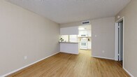 Located at 1750 E Bell Rd in Phoenix, AZ, this one-bedroom, one-bathroom unit offers a well-organized, single-floor layout that maximizes every square foot. The living room is bright and open, featuring light wood-style flooring, neutral beige walls, a textured ceiling, and a window dressed with vertical blinds that filters in natural light. It connects seamlessly to the kitchen via a peninsula-style pass-through counter, making the space feel cohesive and functional. The kitchen is outfitted with white cabinetry, granite-style countertops, white appliances including an electric range with overhead microwave, and a refrigerator — all designed for efficient everyday use. The bedroom is a comfortable, private retreat with plush carpeting, a window with vertical blinds, and dedicated closet space for storage. The full bathroom features a white vanity with granite-style countertop, a framed mirror, and a combined tub-shower unit, all finished in clean, neutral tones. Throughout the unit, the consistent use of light colors and wood-style flooring in the main living areas creates a cohesive, clean aesthetic suited for comfortable urban living in the Phoenix area.