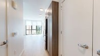 This 300 square foot studio apartment in San Francisco offers a modern and efficient living space. The open-concept design seamlessly integrates the living area, kitchen, and sleeping space, maximizing the use of the compact floor plan. Large windows flood the apartment with natural light, creating an airy and spacious feel despite its modest size.

The kitchen is a standout feature, boasting sleek wood-grain cabinetry, stainless steel appliances, and a clean white backsplash. It's equipped with ample storage and counter space, perfect for preparing meals in a stylish setting. The living area offers flexibility for furniture arrangement, with warm hardwood flooring throughout that adds a touch of elegance.

The bathroom, while compact, is thoughtfully designed with a full-sized bathtub, modern fixtures, and a neutral color palette. Built-in storage solutions and minimalist decor maintain a clutter-free environment, essential for comfortable studio living.

Overall, this apartment combines contemporary design with practical urban living, making efficient use of every square foot. Its location in San Francisco adds to its appeal for those seeking a stylish pied-à-terre in the heart of the city.