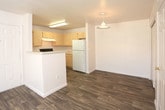 Located at 4515 Arrowhead Ridge Dr SE in Rio Rancho, New Mexico, this single-floor residence offers a well-organized layout with a comfortable blend of hardwood-style flooring and plush carpeting throughout. The open living area connects seamlessly to the kitchen, which is equipped with light wood cabinetry, a black gas range, a white refrigerator, a dishwasher, and ample counter space — all set atop warm hardwood-style flooring. A breakfast bar provides a natural divider between the kitchen and the carpeted living space, which opens to an outdoor area through a sliding glass door fitted with vertical blinds, allowing for generous natural light and exterior views. The bedrooms are carpeted and well-lit, each featuring windows with vertical blinds that bring in natural light. At least one bedroom includes a spacious walk-in closet as well as an additional paneled closet. The bathrooms are clean and functional, featuring light wood vanities with wide countertops, tiled shower-tub combinations — one with a decorative black tile accent border — and bright vanity lighting. A hallway connects the main living areas to the private rooms, creating a practical and straightforward floor plan throughout.