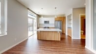 Located at 441 E Erie St in Milwaukee's vibrant Harbor District, this well-designed one-bedroom, one-bathroom residence offers a thoughtful layout with modern finishes throughout. The open-concept kitchen serves as the centerpiece of the living area, featuring warm wood cabinetry paired with crisp white upper cabinets, a large center island with a light stone countertop, pendant lighting, and a full suite of stainless steel appliances. Large sliding glass doors flood the space with natural light and open to a private balcony offering sweeping views of the Milwaukee River and marina. Hardwood-style flooring extends through the main living area and hallway, lending warmth and continuity. The hallway connects the living space to the bedroom, bathroom, closet, and utility room in a practical arrangement. The bedroom features soft carpeting and a dedicated closet. The bathroom is finished with a wood-accented floating vanity, built-in wood shelving, and a glass-enclosed walk-in shower. Recessed lighting throughout the unit contributes to a clean, contemporary ambiance. This residence combines modern urban design with functional living in a prime Milwaukee waterfront location.