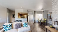 This thoughtfully designed 2-bedroom, 2-bathroom single-floor residence offers a comfortable and stylish living experience. The open-concept layout seamlessly connects the living room, dining area, and kitchen, all finished with durable wood-style flooring. The kitchen features stainless steel appliances, dark wood cabinetry, recessed lighting, and a breakfast bar with bar stool seating — ideal for both casual dining and entertaining. The living room is anchored by a tiled fireplace and sliding glass doors that open to a private outdoor patio, filling the space with natural light. An elegant arched hallway leads to the private quarters. The spacious primary bedroom boasts a distinctive reclaimed wood accent wall, plush carpeting, a walk-in closet, and direct access to an outdoor balcony. The second bedroom also features carpeting and a well-organized walk-in closet. Both bathrooms are clean and functional, with one featuring a full tub-shower combination. A dedicated laundry room provides added convenience, complete with cabinetry and counter space. Throughout the home, neutral gray tones create a cohesive, modern ambiance that is both inviting and versatile.