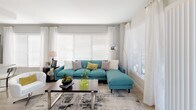 This well-designed single-floor residence offers a thoughtful layout with modern finishes and a cohesive contemporary aesthetic. The open-concept kitchen is a standout feature, showcasing dark wood-grain cabinetry, granite countertops, a subway tile backsplash, and a full suite of stainless steel appliances including a range, over-the-range microwave, and refrigerator. A kitchen island with an integrated sink and dishwasher adds both functionality and style, while light wood-style flooring ties the space together seamlessly.

The living room is bathed in natural light from a generous array of windows dressed with sheer curtains and blinds, creating an airy and welcoming atmosphere. Light-toned walls and wood-style flooring carry throughout the common areas, lending the space a clean, open feel.

The primary bedroom features plush carpeting, a vibrant accent wall, and direct access to an en-suite bathroom. The second bedroom is equally well-appointed with soft carpeting, neutral tones, and its own en-suite access. Both bathrooms are finished with granite-topped vanities, dark wood-grain cabinetry, and classic white subway tile surrounding the bathtub and shower areas, delivering a polished, hotel-inspired feel throughout.