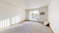 Located at 319 Laudenbach Ct in Saint Cloud, Minnesota, this single-floor unit offers a clean, functional layout designed for comfortable everyday living. The spacious living room is carpeted and filled with natural light streaming through a large sliding glass door fitted with vertical blinds, which also provides access to an outdoor view. A wall-mounted air conditioning unit and baseboard heating ensure year-round climate comfort.

The galley-style kitchen is well-appointed with warm honey-toned wood cabinetry lining both walls, offering generous storage space. White appliances including a refrigerator, electric range, and dishwasher are included, complemented by light countertops and tile flooring that keep the space bright and easy to maintain.

The bedrooms are carpeted and bathed in natural light from sliding windows that overlook the surrounding neighborhood and mature trees. Each bedroom features built-in closets with wood-panel bifold doors, providing ample storage. The full bathroom is neatly finished with a tub/shower combination, a wood-vanity, and tile flooring in a clean, neutral palette.

The entry area transitions between tile and carpet flooring, offering a practical and welcoming introduction to the space. Throughout, white walls, wood trim accents, and textured ceilings create a cohesive, understated aesthetic.