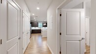 Located at 881 W Warren Ave in Longwood, FL, this thoughtfully designed one-bedroom, one-bathroom unit offers a clean, modern aesthetic across a single floor. Light-toned wood-style flooring runs throughout the space, creating a cohesive and contemporary feel.

The kitchen is a standout feature, showcasing rich dark cabinetry with sleek hardware, white quartz countertops, a herringbone-patterned tile backsplash, and a full suite of stainless steel appliances including a refrigerator with ice maker, electric range, and built-in microwave. A kitchen island provides additional prep and seating space, while pendant lighting adds a polished finishing touch.

The living room is bright and open, benefiting from multiple windows dressed with horizontal blinds that invite natural light and greenery views. A ceiling fan adds comfort to the airy space.

The bedroom is generously proportioned, featuring a bank of windows framing outdoor views and providing ample natural light. It connects to a walk-in closet outfitted with wire shelving for organized storage.

The bathroom is finished with dark wood-tone cabinetry, a quartz-topped vanity, and a full tub-shower combination. A hallway near the entrance provides additional closet storage, completing this well-appointed, move-in-ready unit.