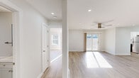 Located in the Briar Knoll neighborhood of Toms River, NJ, this single-floor home presents a clean, modern aesthetic defined by light hardwood flooring, neutral gray-white walls, and crisp white trim throughout. Recessed lighting is installed across the main living areas, supplemented by a contemporary ceiling fan in the spacious main living room, which also features a sliding glass door providing direct access to an outdoor deck and views of surrounding greenery. Natural light flows generously through multiple windows and the sliding door, creating a bright and airy atmosphere across every room.

The open layout connects the living area to a dining space and kitchen area, where cabinetry with sleek hardware complements the light-toned floors. Bedrooms are well-proportioned, each with natural light from windows and recessed lighting overhead. One bedroom includes a built-in closet with a standard hanging rod for organized storage.

The bathrooms are finished with large-format gray tile flooring and wall tile accented by a distinctive herringbone mosaic stripe. One bathroom features a tub-shower combination, while another offers a dedicated walk-in shower stall, both outfitted with brushed nickel fixtures for a cohesive, modern look throughout.