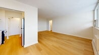 Located at 6320 Valley Way in Niagara Falls, Ontario, this well-appointed one-bedroom, one-bathroom unit offers a clean, modern aesthetic with a thoughtfully designed layout across a single floor. Light-toned hardwood flooring flows consistently throughout the main living areas, lending warmth and cohesion to the space.

The living room is generously sized, featuring a wide bank of floor-to-ceiling windows that flood the area with natural light and provide access to a private balcony, offering pleasant outdoor views. Baseboard heating runs along the window wall, ensuring year-round comfort.

The galley-style kitchen is efficiently laid out with crisp white cabinetry extending to the ceiling, white quartz countertops, a stainless steel double sink, and a full suite of stainless steel appliances including a refrigerator, electric range, and dishwasher. A window at the end of the kitchen allows additional natural light to filter through.

The bedroom is a comfortable size, featuring a large window, light hardwood floors, and a sliding closet door for practical storage. The bathroom is finished with large-format grey tile on both the floors and lower walls, and includes accessibility-friendly grab bars. Hallways connect the rooms with ease, completing this functional and modern living space.