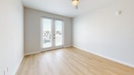 Located at 5541 N 22nd St in Tampa, FL, this modern 2-bedroom, 2-bathroom residence offers a clean, contemporary design with light wood flooring running throughout the entire space. The open-concept kitchen and living area serves as the heart of the home, featuring sleek white cabinetry extending to the ceiling, stainless steel appliances including a gas range, microwave, refrigerator, and dishwasher, complemented by white quartz countertops and a kitchen island with pendant lighting overhead. The living area flows seamlessly from the kitchen, creating an airy, connected feel. The primary bedroom is generously proportioned, offering a walk-in closet with built-in shelving for ample storage. The second bedroom includes a ceiling fan and a large window that invites natural light and outdoor views, while another room features double glass doors opening to the exterior. Both bedrooms include dedicated closet space. The two bathrooms are finished in crisp white tile; one features a frameless sliding glass shower enclosure, while the other offers a full shower-tub combo. Neutral walls, recessed lighting, and modern hardware throughout contribute to the home's clean, cohesive aesthetic.