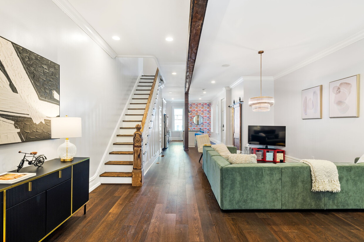 A captivating living room with a view of the grand foyer and elegant stairs, offering ample seating - 5311 Carnegie St