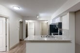 Located in the heart of Edmonton at 10803 Jasper Ave NW, this well-appointed 2-bedroom, 2-bathroom unit offers a thoughtfully designed open-concept layout that maximizes every square foot. The combined living, dining, and kitchen area forms the heart of the home, anchored by a sleek kitchen featuring white cabinetry, granite stone countertops, a tile backsplash, and a full suite of black appliances including a refrigerator, range, microwave, and dishwasher. A peninsula with an undermount sink provides both additional prep space and a natural division between the kitchen and living areas. Warm hardwood-style flooring runs consistently throughout the unit, complementing the neutral, light-toned walls. The primary bedroom is a comfortable, well-proportioned retreat with a dedicated walk-in closet. The second bedroom benefits from a large floor-to-ceiling window, filling the room with natural light. Both bathrooms are finished with granite vanity countertops and white cabinetry. Additional storage is provided by two closets, and the unit includes a dedicated laundry area and utility room for added convenience. The overall aesthetic is clean, contemporary, and move-in ready.