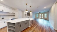 This contemporary 990 square foot home in Austin, TX offers a harmonious blend of style and functionality. The single-story layout encompasses two bedrooms, including a 150 square foot primary bedroom, and two full bathrooms. The heart of the home is an open-concept kitchen and living area, perfect for entertaining or relaxed family living. Rich hardwood floors flow throughout, adding warmth and elegance to the space. The kitchen boasts sleek white cabinetry, stainless steel appliances, and a subway tile backsplash, creating a clean and modern aesthetic. Both bathrooms feature modern fixtures, including glass shower enclosures and crisp white tiling. Ample storage is provided by two closets, one showcasing built-in shelving for optimal organization. Large windows allow natural light to flood the rooms, enhancing the airy feel of the space. Modern lighting fixtures, including stylish pendant lights in the kitchen, add to the home's contemporary ambiance. The neutral color palette throughout provides a versatile canvas for various decorating styles, making this Austin residence a perfect blend of comfort and modern design.