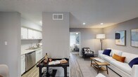This single-story 1-bedroom, 1-bathroom unit offers a thoughtfully designed layout that maximizes both comfort and functionality. The open-concept living area welcomes you with wood-style plank flooring, recessed lighting, and a large window that fills the space with natural light. The living room provides ample room for seating and storage, complemented by neutral gray walls that lend a modern, cohesive feel throughout.

The kitchen is outfitted with white shaker-style cabinetry, granite-look countertops, and stainless steel appliances including an electric range with overhead vent hood and a dishwasher. A prep bar area connects the kitchen to the living space, adding convenience for entertaining.

The bedroom is a comfortable retreat featuring a ceiling fan, wood-style flooring, a window with natural light, and generous space for a full furniture arrangement. The room's soft gray palette and warm wood tones create a relaxing atmosphere.

The bathroom features a white vanity with an undermount sink, a large framed mirror, wood-tone hardware accents, and matching wood-style flooring. A textured ceiling is present throughout the unit, adding a classic touch to the overall design.
